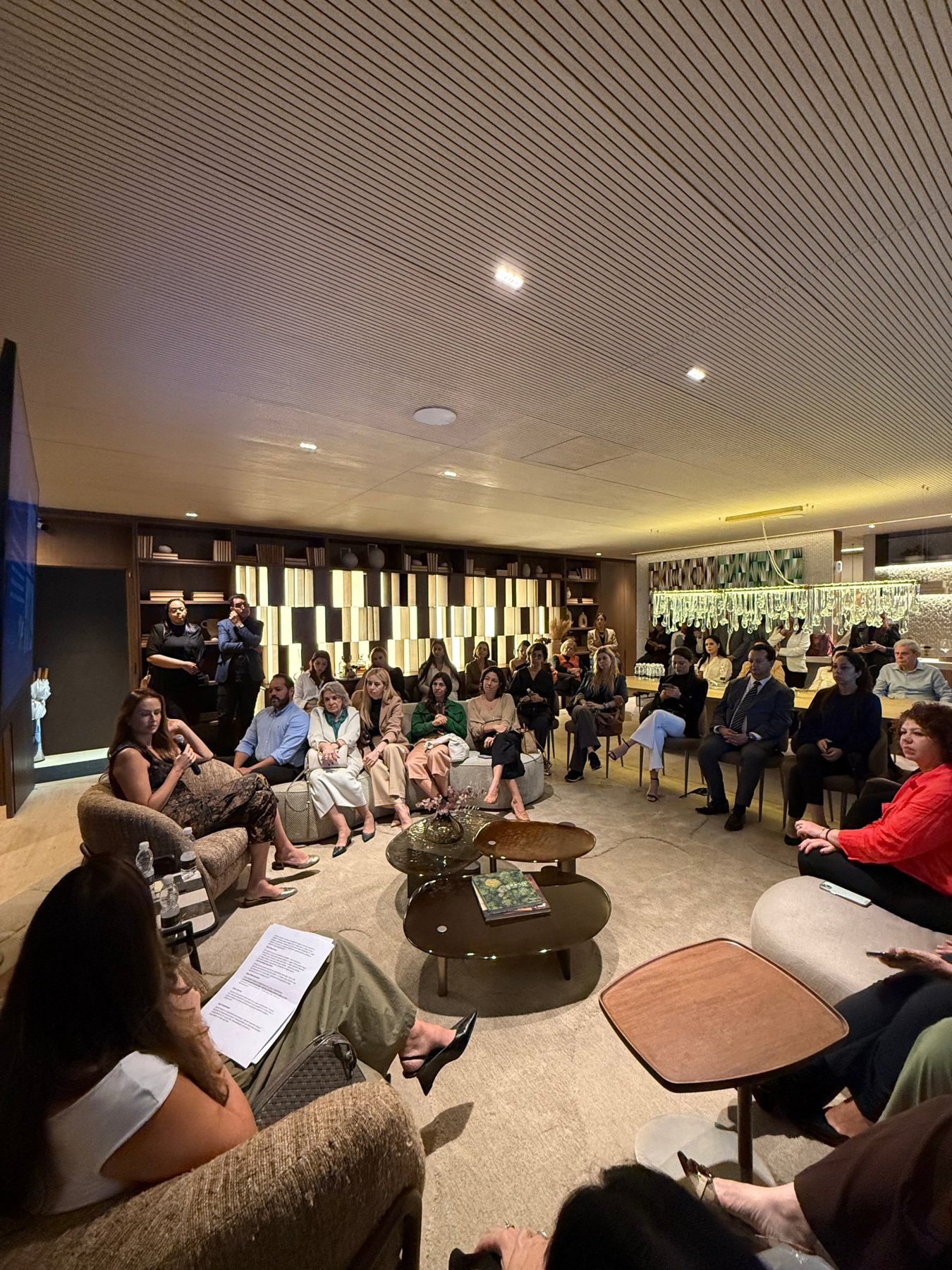 Público reunido em roda para um talk em lounge de empreendimento
